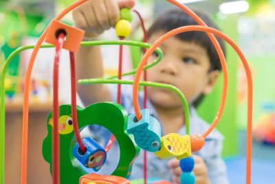A small child playing with a toy is concentrated and learning
